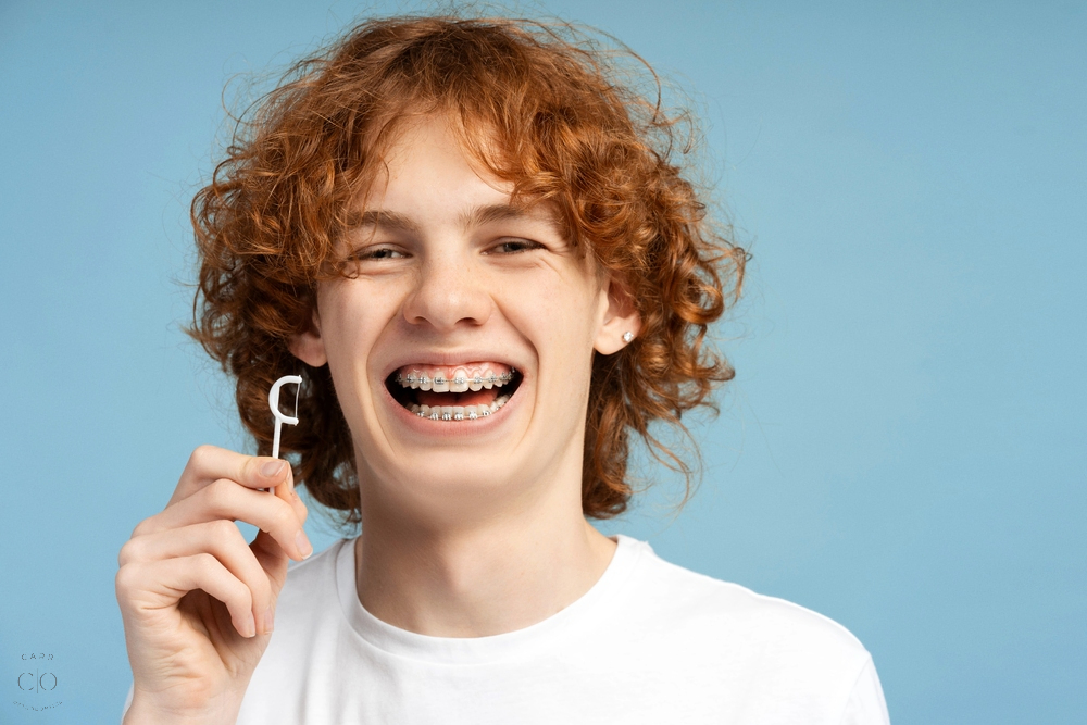 closeup image smiling teenager curly red hair metal braces - How to Floss with Braces in Fairview, TN